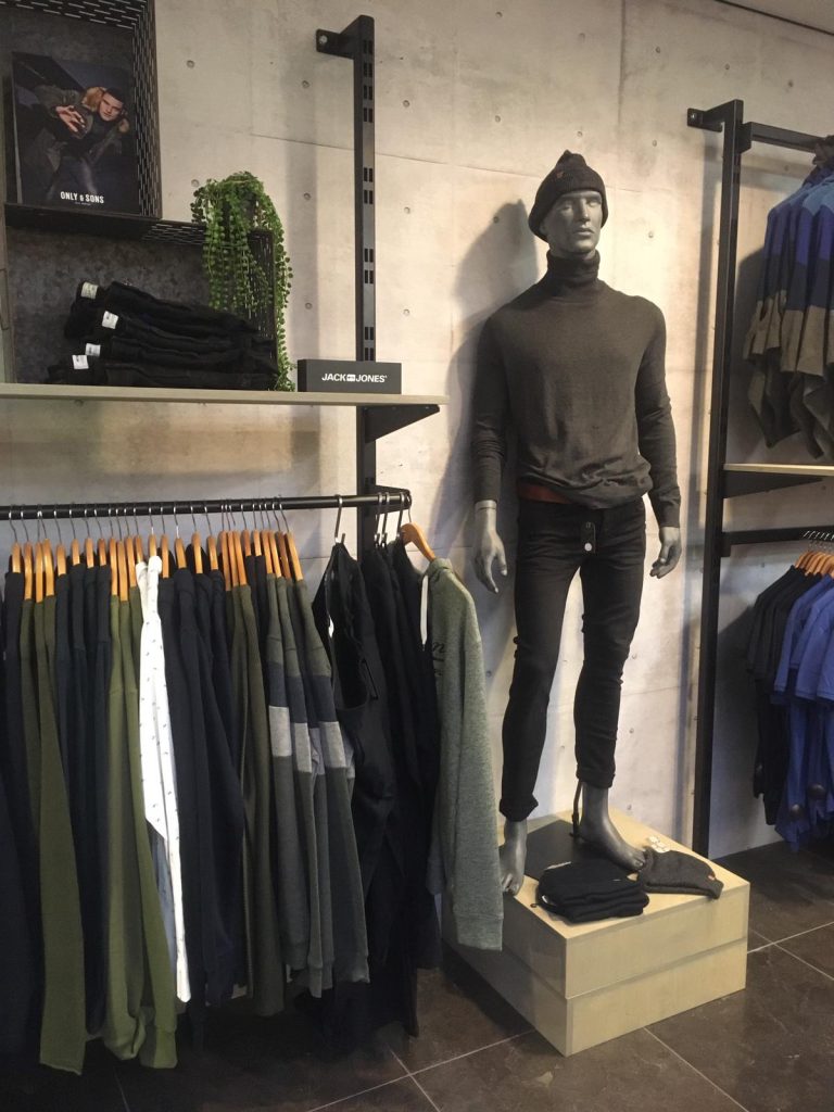 Winkelinterieur met kleding en wandbeelden van Okay